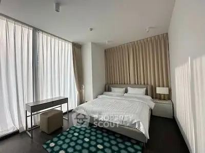 Modern bedroom with large windows and stylish decor in a luxury apartment.