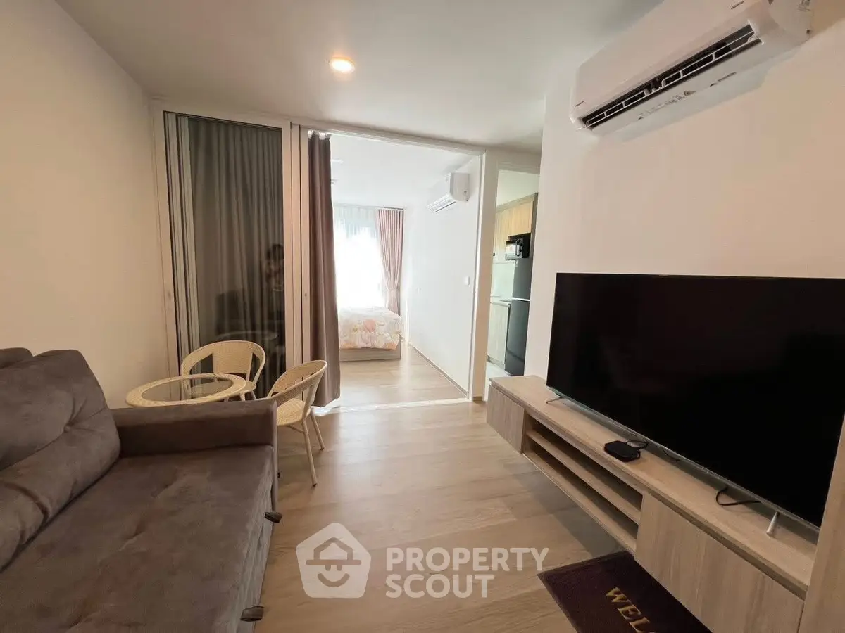 Modern living room with air conditioning and TV, open to cozy bedroom