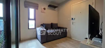 Cozy living room with modern sofa and flat-screen TV, perfect for relaxation.