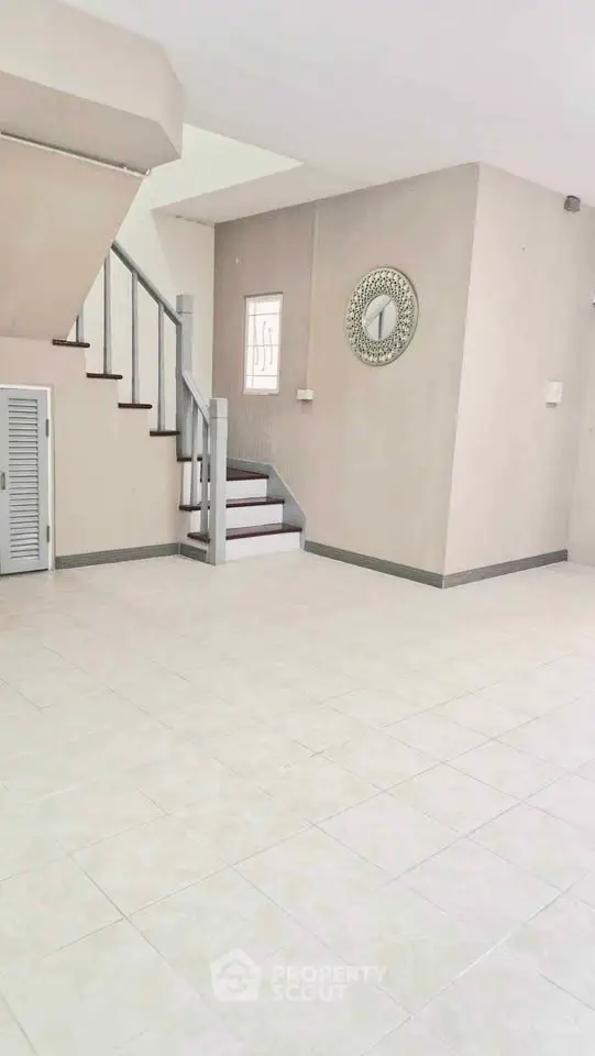 Spacious open-plan living area with staircase and modern decor.