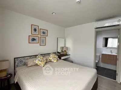 Cozy bedroom with modern decor and ensuite bathroom in a stylish apartment.