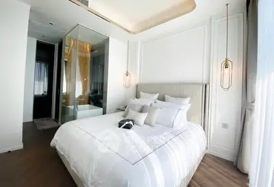 Luxurious modern bedroom with elegant lighting and glass-enclosed bathroom.