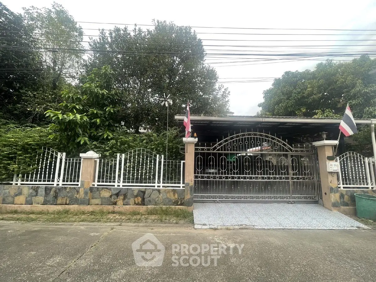 Charming gated property with lush greenery and secure entrance in a serene neighborhood.