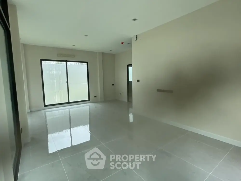 Spacious and bright living area with glossy tiled flooring, large windows allowing ample natural light, and a neutral color palette ready for personalization.
