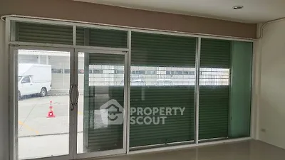 Spacious room with large glass windows and green blinds, ideal for natural light.