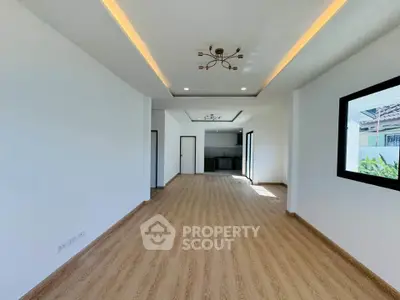 Spacious open-plan living room with modern lighting and wooden flooring