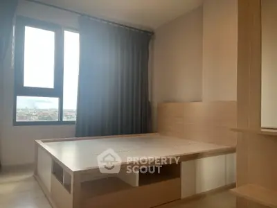 Modern bedroom with large window and wooden bed frame, offering a bright and airy ambiance.