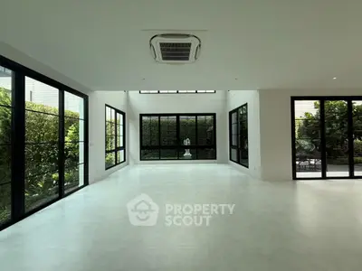 Spacious modern living room with large windows and garden view, perfect for natural light lovers.