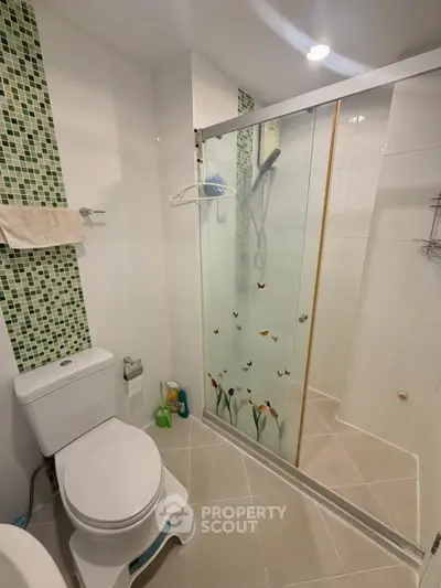 Modern bathroom with glass shower and mosaic tile accents