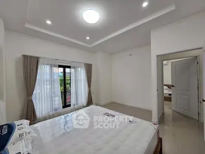 Spacious bedroom with large window and modern lighting, perfect for a cozy retreat.