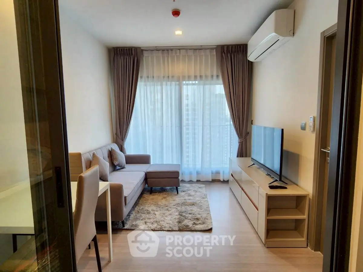 Modern living room with cozy sofa, TV, and large window in a stylish apartment.