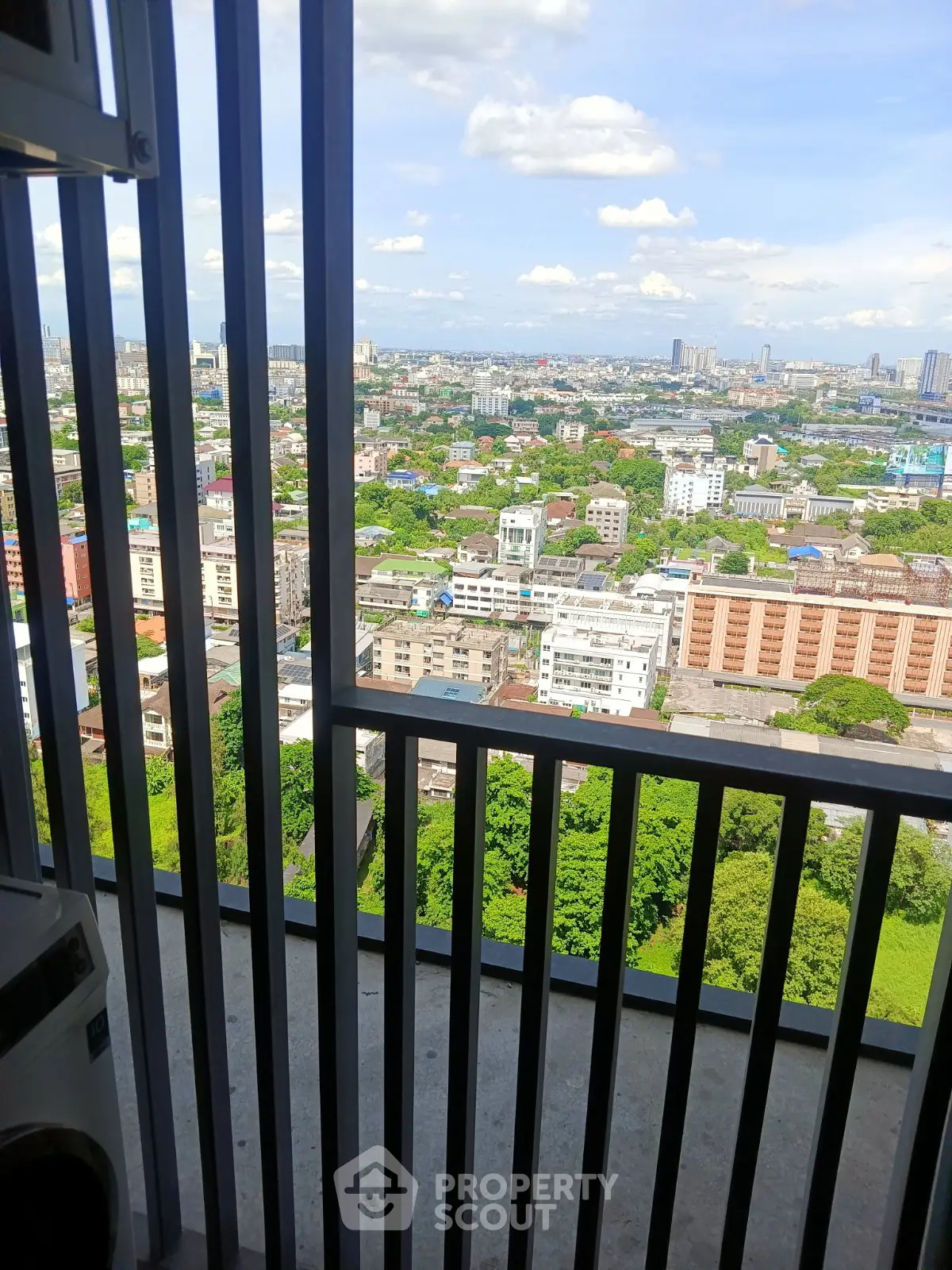 Stunning high-rise balcony view overlooking vibrant cityscape and lush greenery, perfect for urban living.