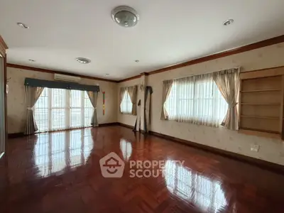 Spacious empty living room with hardwood floors and large windows