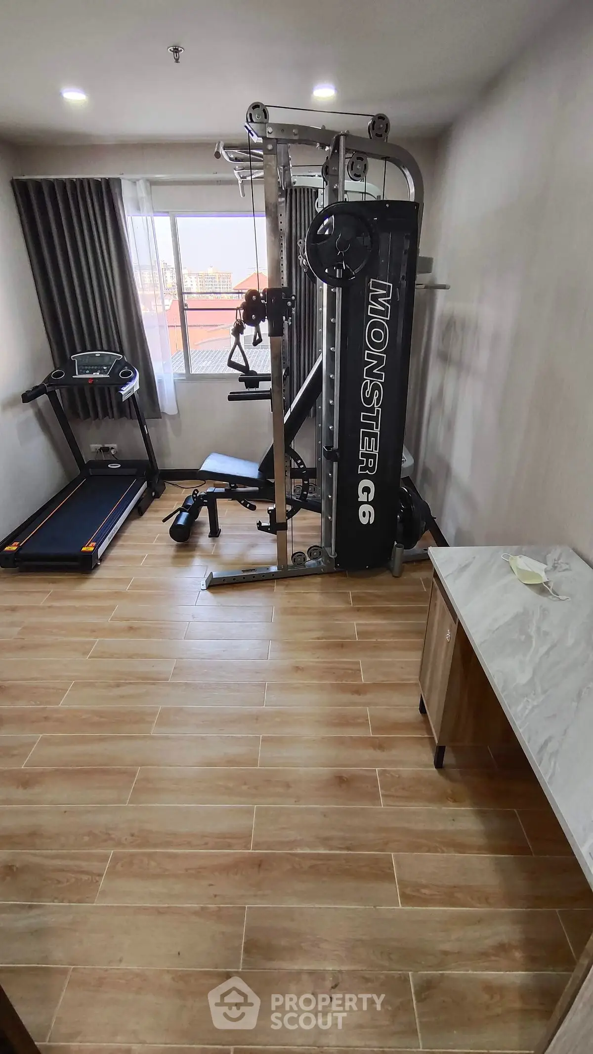 Spacious home gym with modern equipment and wooden flooring