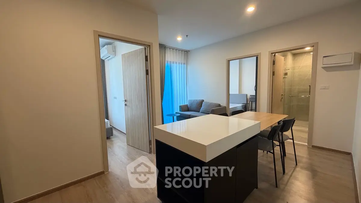 Modern open-plan living area with sleek kitchen island and cozy seating, perfect for urban living.