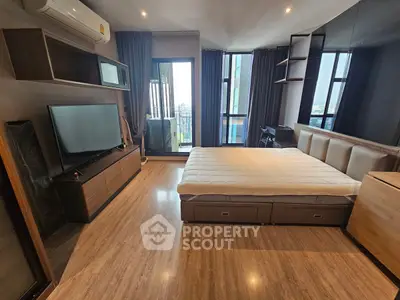 Modern bedroom with large windows and stylish furnishings in a high-rise apartment.