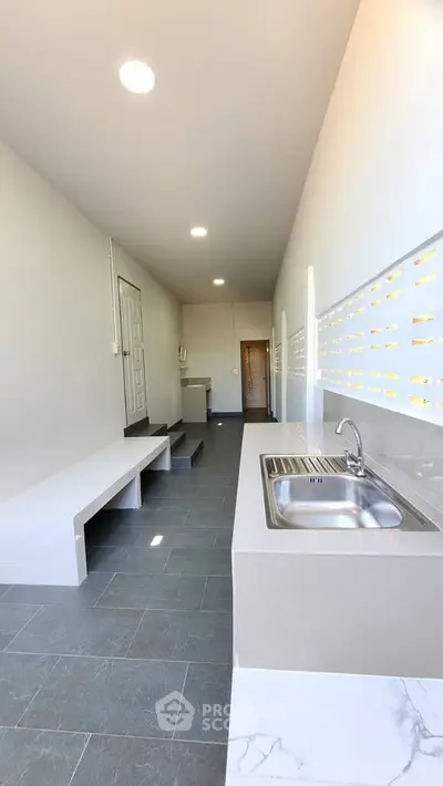 Modern minimalist kitchen with sleek countertops and ample natural light.