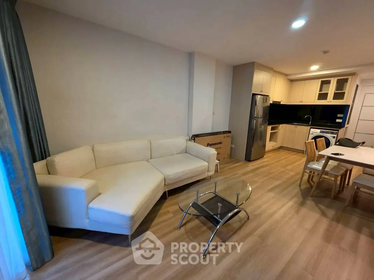 Modern open-plan living room with sleek kitchen and cozy seating area.