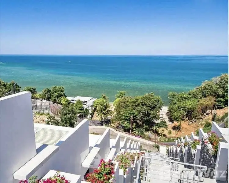 Stunning ocean view from modern hillside property with lush greenery and clear blue skies.