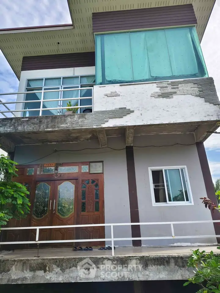 Charming two-story house with unique architectural design and spacious balcony, perfect for modern living.