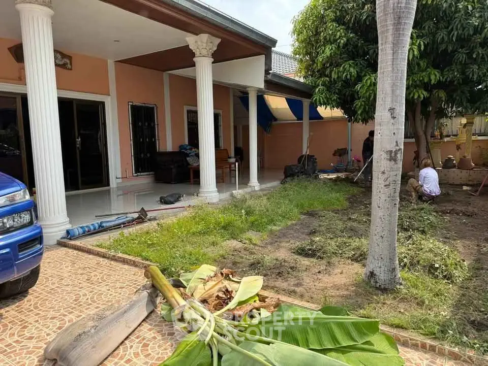 Charming single-story home with spacious garden and elegant columns, perfect for outdoor living.