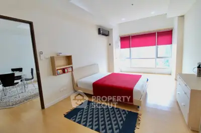 Spacious bedroom with modern decor and large window offering natural light