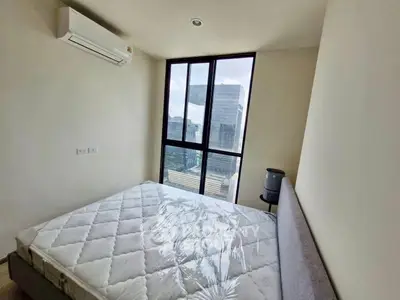 Modern bedroom with large window offering city view, featuring air conditioning and minimalist design.