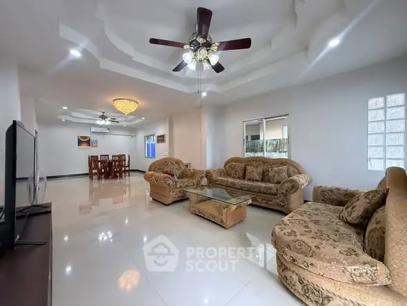 Spacious living room with elegant ceiling fan and plush sofas in a modern home.