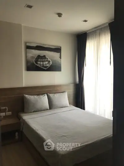 Cozy bedroom with natural light and modern decor, perfect for relaxation and comfort.