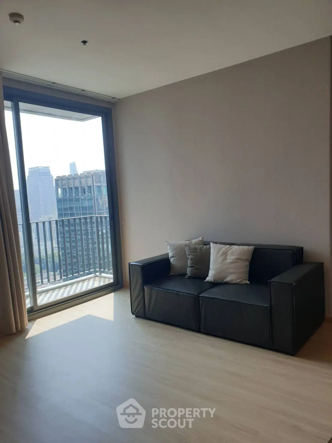 Modern living room with city view and sleek black sofa