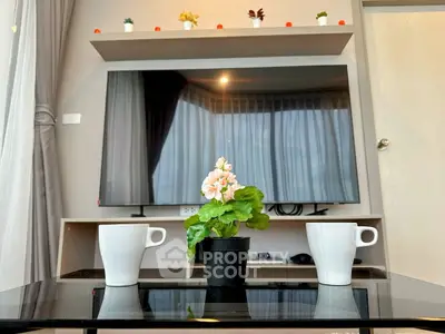 Modern living room with large TV, stylish decor, and cozy ambiance.