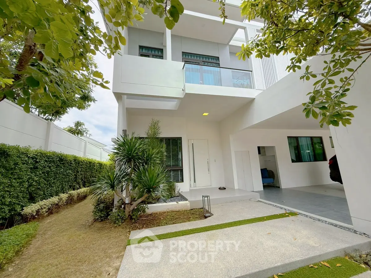 Modern two-story white house with lush garden and spacious driveway