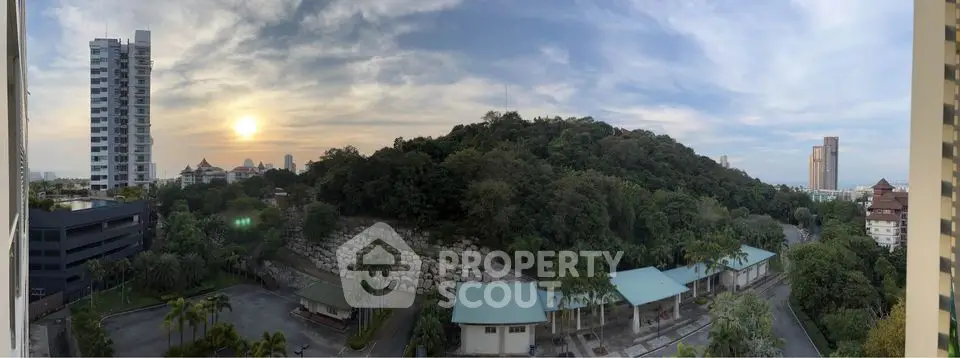 Stunning panoramic view of lush greenery and urban skyline at sunset, perfect for serene living.