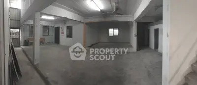 Spacious open-plan interior with concrete flooring and ceiling fan, ideal for versatile use.