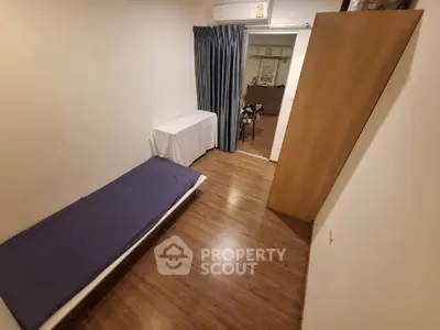 Cozy minimalist bedroom with wooden flooring and air conditioning