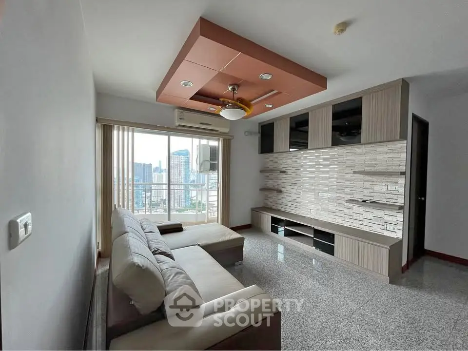 Spacious living room with modern ceiling design and city view balcony.
