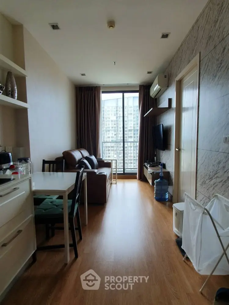 Modern living room with city view, featuring cozy seating and sleek decor.