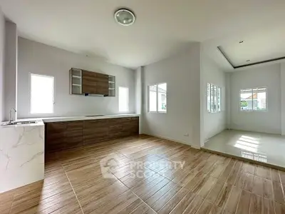 Spacious open layout kitchen with modern wooden cabinets and ample natural light.