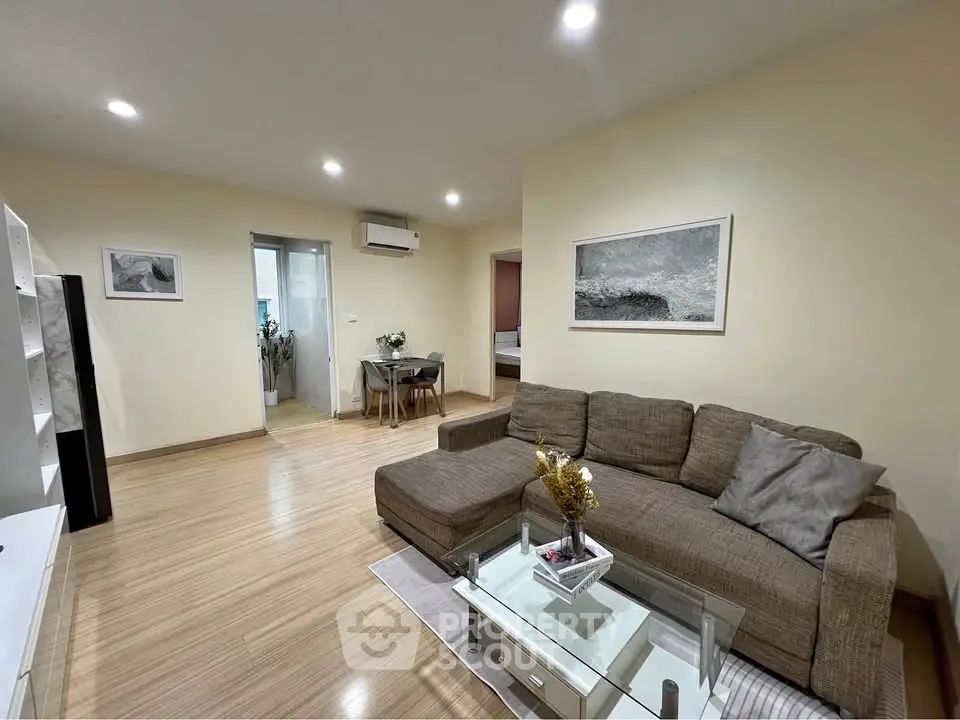 Spacious living room with modern decor and cozy seating area in a stylish apartment.