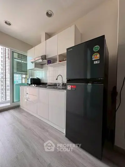 Modern kitchen with sleek cabinets and stainless steel appliances in a bright apartment.