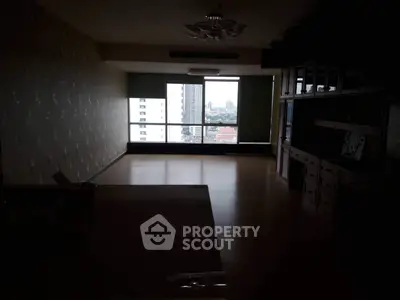 Spacious living room with large window offering city view in modern apartment.