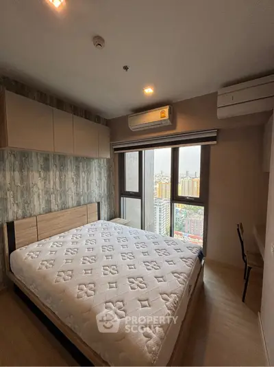 Modern bedroom with large window offering city view, featuring a comfortable bed and air conditioning.
