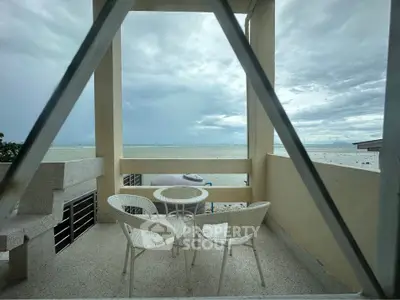 Stunning beachfront balcony with ocean view and cozy seating area