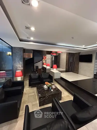 Luxurious modern living room with sleek black leather sofas and elegant marble accents.