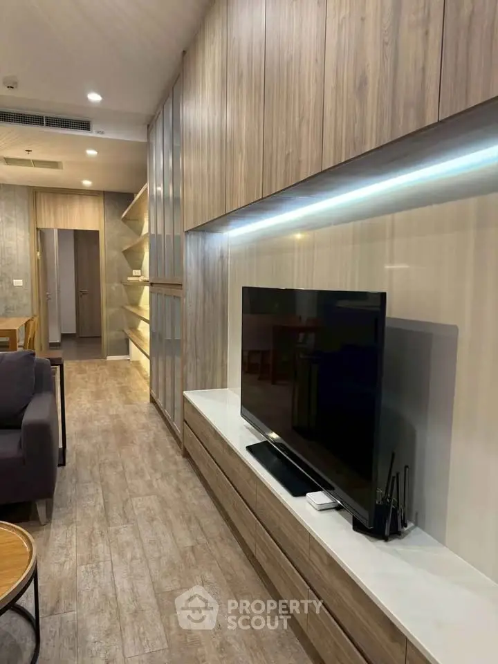 Modern living room with sleek wooden paneling and large flat-screen TV, perfect for stylish urban living.