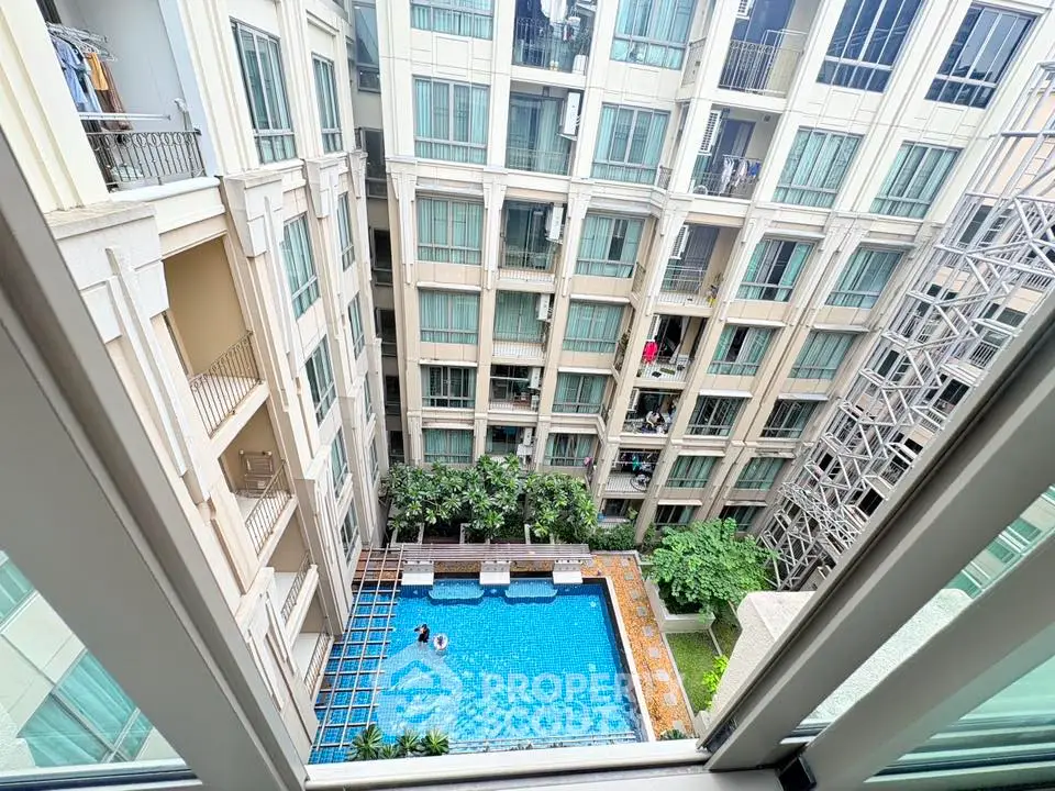 Stunning view of modern apartment building with pool from high floor balcony.