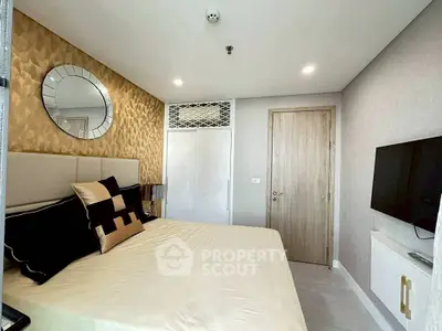 Modern bedroom with stylish decor and wall-mounted TV in a luxury apartment.