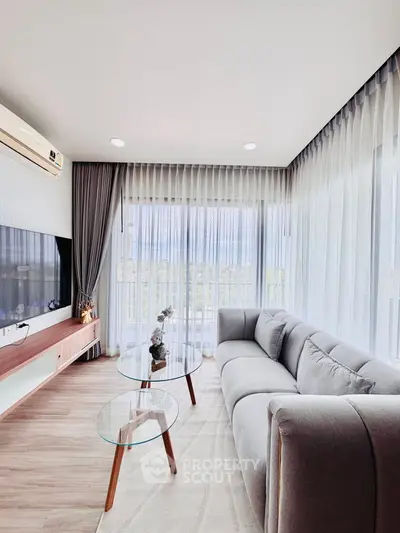 Modern living room with elegant decor and large windows offering natural light