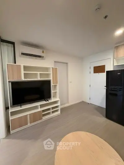 Modern living room with sleek TV unit and air conditioning in a stylish apartment.