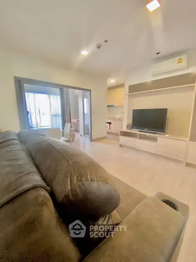 Spacious living room with modern furnishings and large TV, perfect for relaxation.